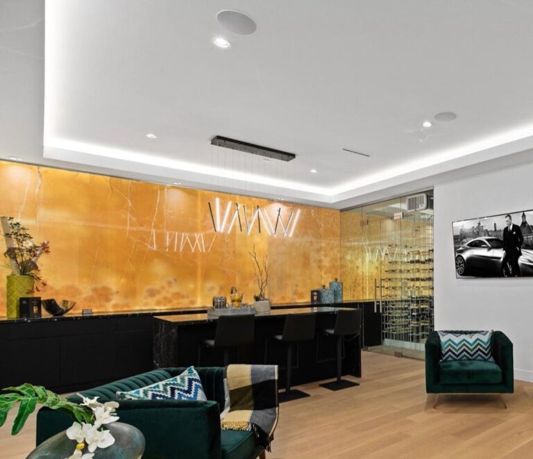 Luxury home lounge with a backlit onyx feature wall, black marble bar and a glass-enclosed wine room